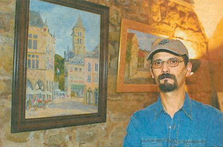 La photo : Abdelatif Zeradi devant ses oeuvres